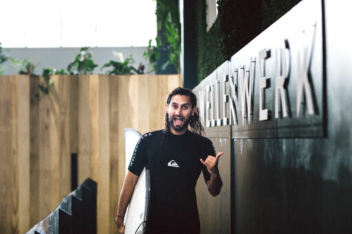 Surfer mit surfboard zeigt hang loose