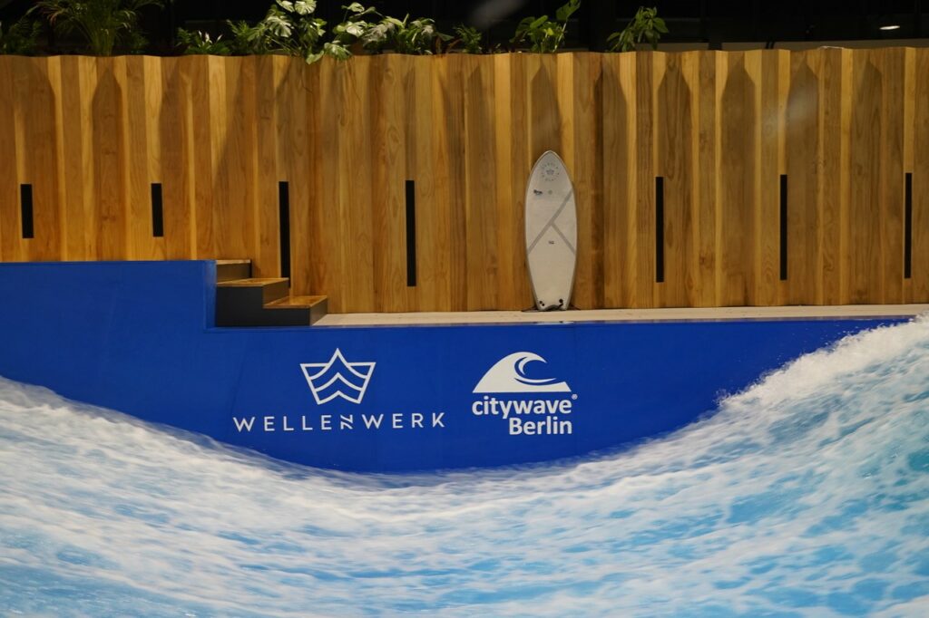 stehende Welle im Surfbecken neben den Firmenlogos