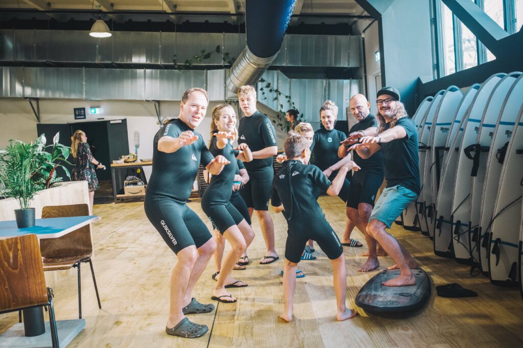 Surfkursteilnehmer üben Trockenübungen