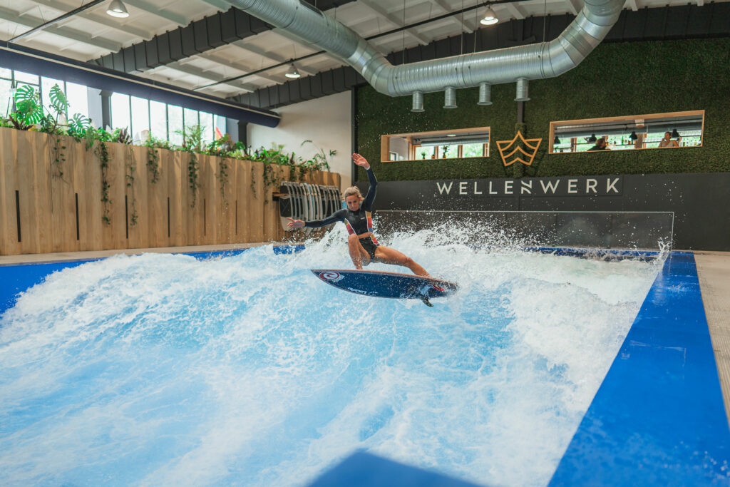 Surferin springt auf Indoor Surfwelle