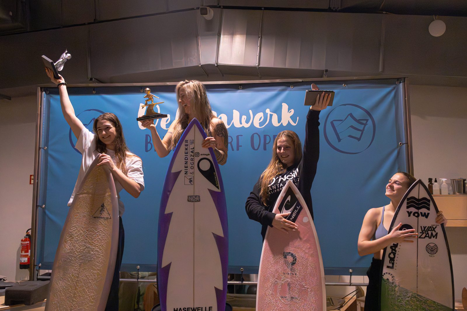 Siegerinnen jubeln mit Pokalen bei der Siegerehrung des Berlin Surf Open 2025