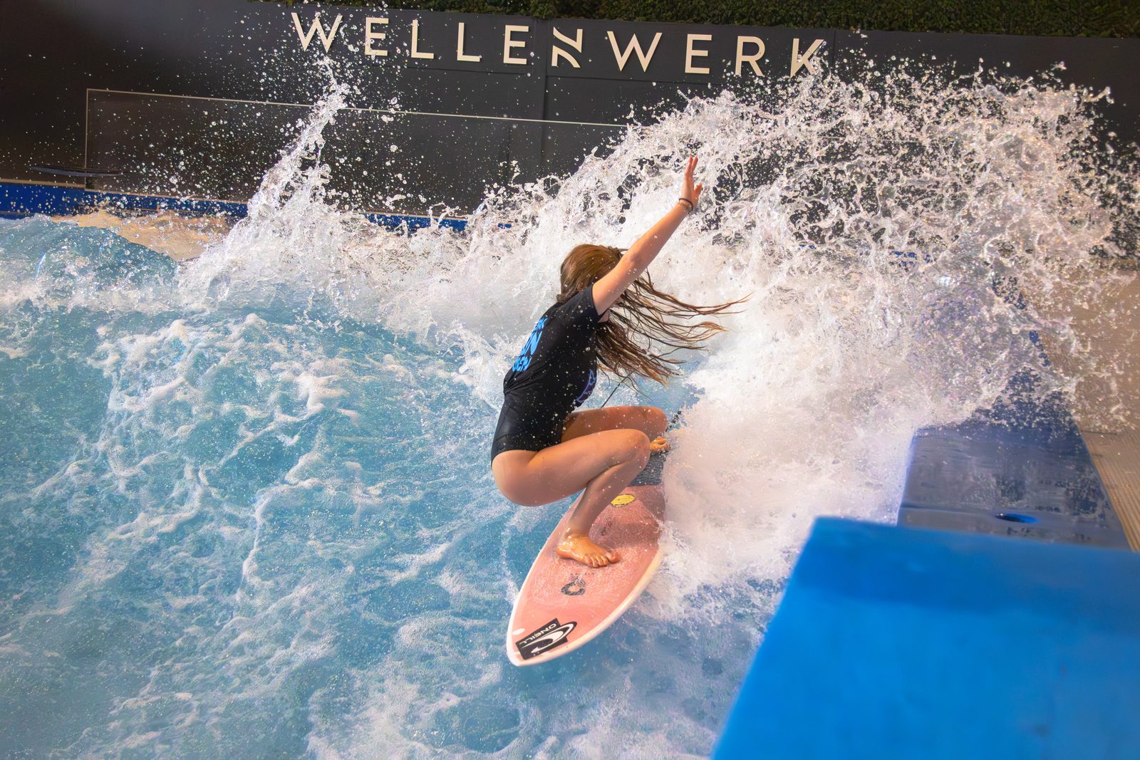 Surferin mit großem Spray beim Berlin Surf Open 2025 im Wellenwerk